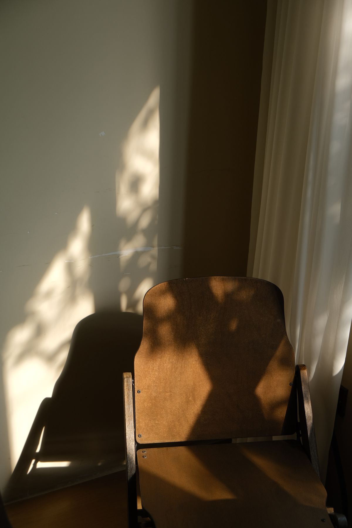 An empty chair beside a window in soft afternoon light